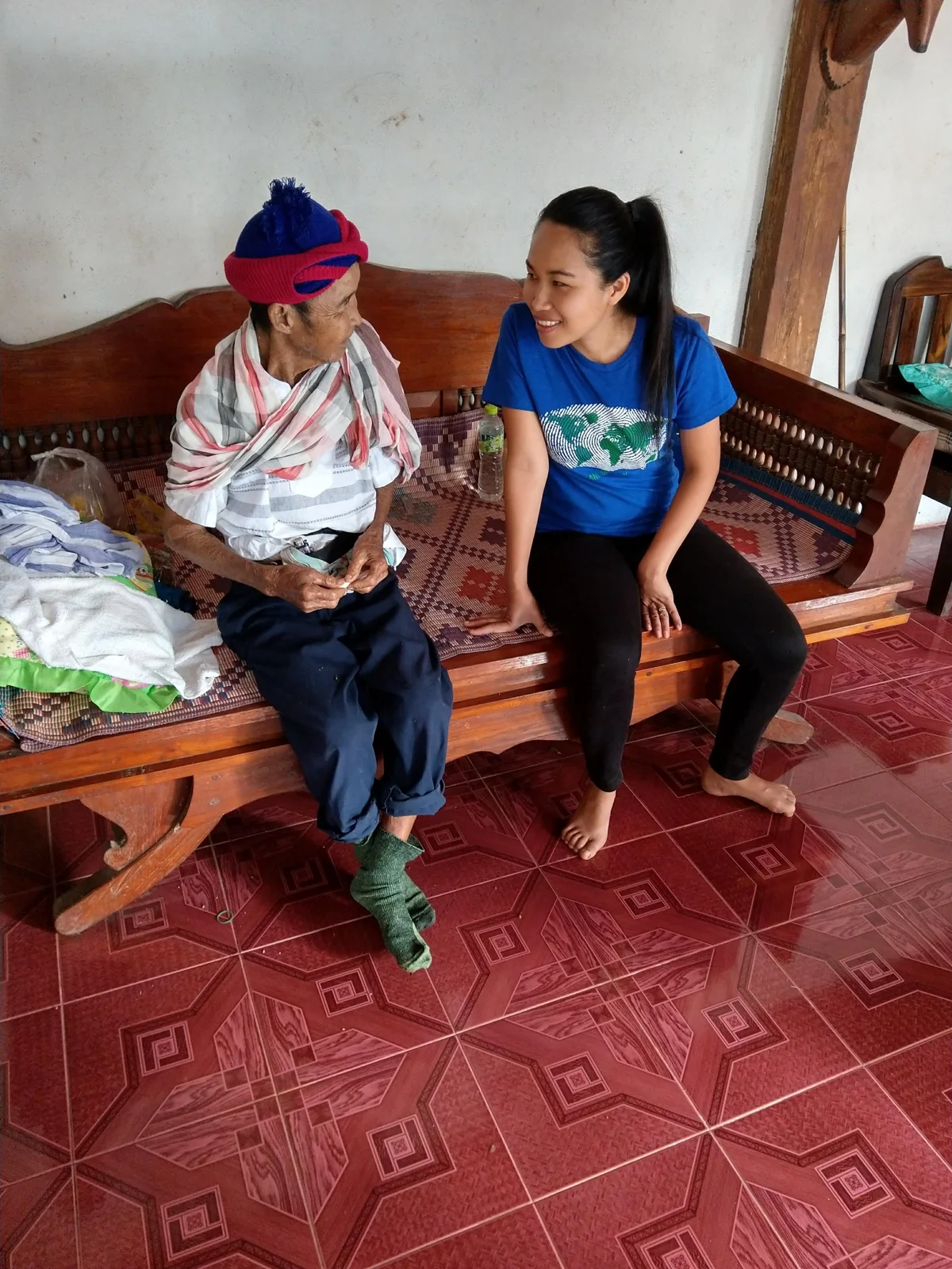 Two women in conversation, one an elder wearing a traditional headdress
