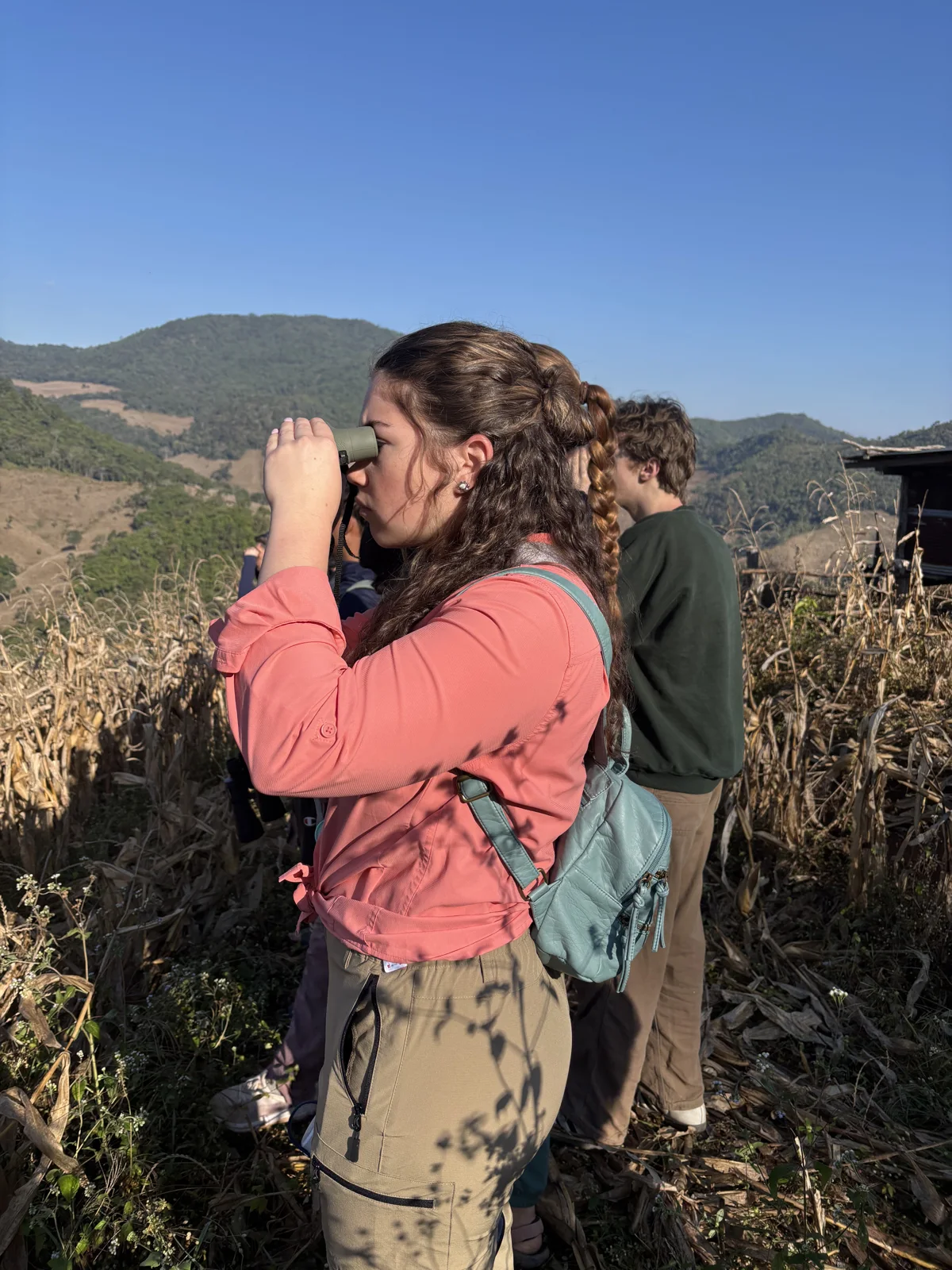 Participants using binoculars to observe the landscape