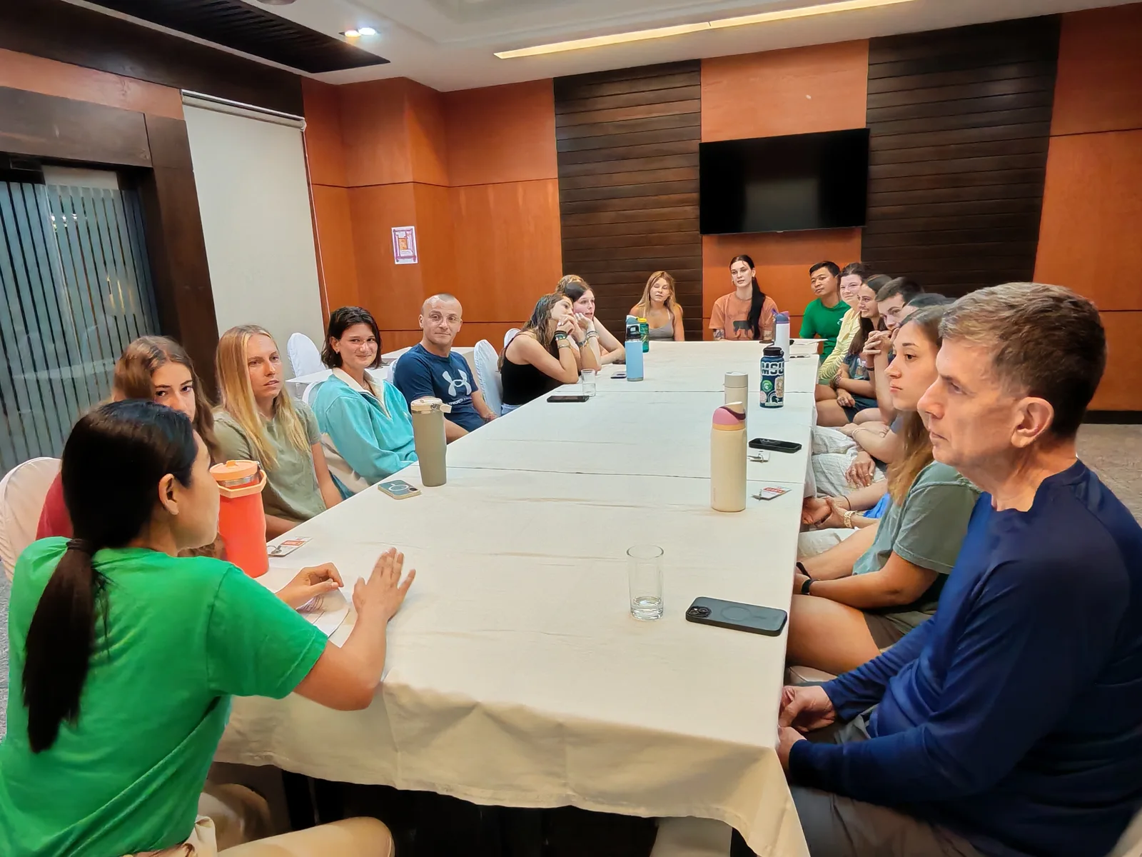 A group listening to a speaker around a table