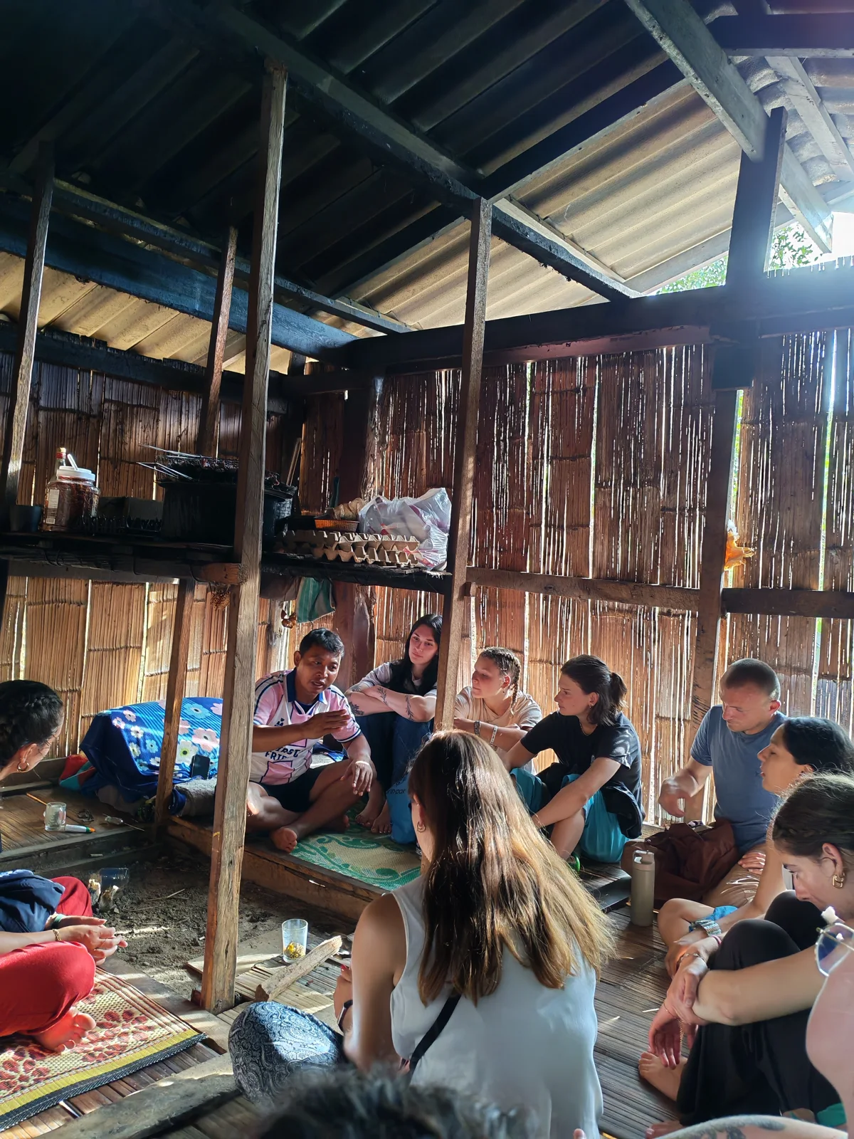 Participants listening together during a session in a wooden village home