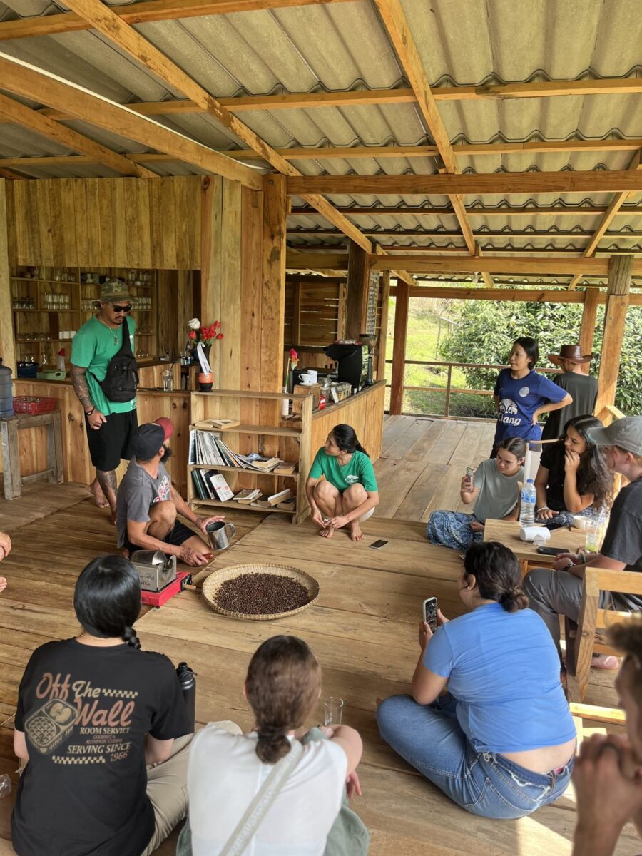Home Participants gathered in a circle with a local host during a community workshop